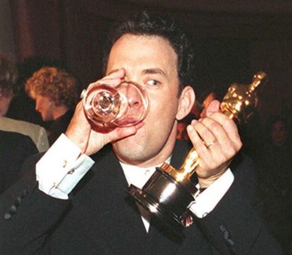 Tom Hanks bebendo com o Oscar na festa da premiação